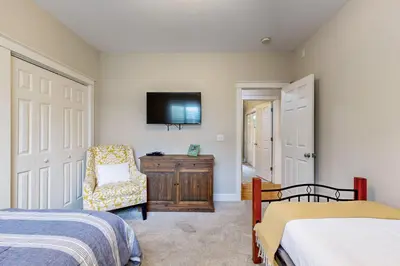 a bedroom with two beds and a tv on the wall at Colorful house near the beach with shared swimming pool in Santa Rosa Beach