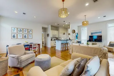 a living room with couches and a kitchen at Colorful house near the beach with shared swimming pool in Santa Rosa Beach