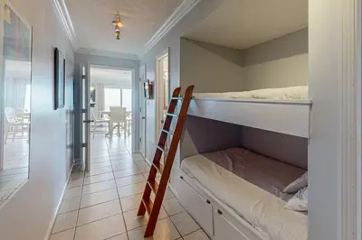 a room with a bunk bed and a ladder at Lovely first floor condo with ocean views patio & grill - steps from the beach in Santa Rosa Beach
