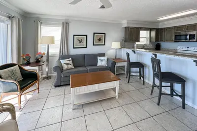 a living room with a couch and a table at Lovely first floor condo with ocean views patio & grill - steps from the beach in Santa Rosa Beach