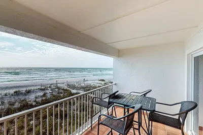 a balcony with a table and chairs and the ocean at Charming gulf-front 2nd floor condo in South Walton Outdoor showers on-site in Santa Rosa Beach