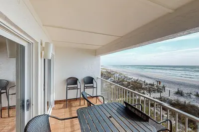 a balcony with a table and chairs and the beach at Charming gulf-front 2nd floor condo in South Walton Outdoor showers on-site in Santa Rosa Beach