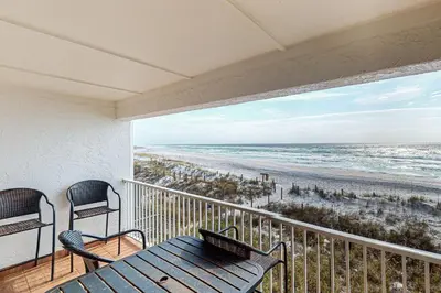 a balcony with a table and chairs and the beach at Charming gulf-front 2nd floor condo in South Walton Outdoor showers on-site in Santa Rosa Beach