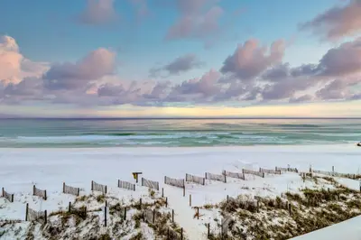 a beach with a fence in the sand at Charming gulf-front 2nd floor condo in South Walton Outdoor showers on-site in Santa Rosa Beach
