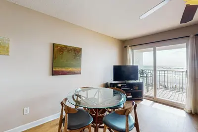a living room with a glass table and a television at Charming gulf-front 2nd floor condo in South Walton Outdoor showers on-site in Santa Rosa Beach