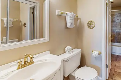 a bathroom with a sink and a toilet and a mirror at Charming gulf-front 2nd floor condo in South Walton Outdoor showers on-site in Santa Rosa Beach