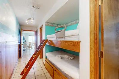 a room with two bunk beds and a hallway at 1st floor gulf front condo with amazing views charcoal grills - walk to the beach in Santa Rosa Beach