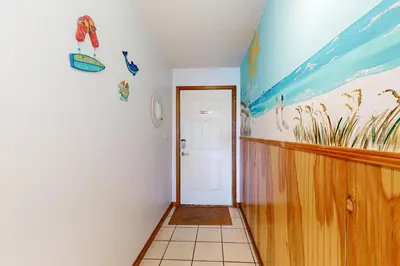 a hallway with a room with a painting on the wall at 1st floor gulf front condo with amazing views charcoal grills - walk to the beach in Santa Rosa Beach