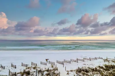 a beach with a fence in the sand and the ocean at 1st floor gulf front condo with amazing views charcoal grills - walk to the beach in Santa Rosa Beach