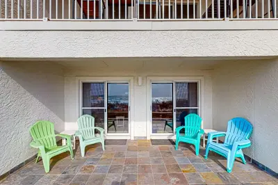 three blue and green chairs sitting on a patio at 1st floor gulf front condo with amazing views charcoal grills - walk to the beach in Santa Rosa Beach