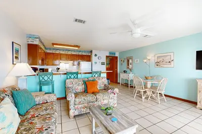 a living room with a couch and a table at 1st floor gulf front condo with amazing views charcoal grills - walk to the beach in Santa Rosa Beach