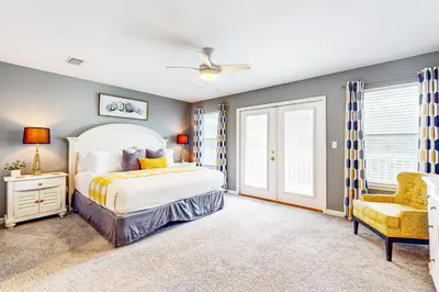 a bedroom with a bed and a chair at Luxury home with private saltwater pool spa gazebo & deck - walk to beach in Santa Rosa Beach