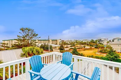 a pair of blue chairs sitting on a balcony at Luxury home with private saltwater pool spa gazebo & deck - walk to beach in Santa Rosa Beach
