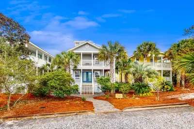 a house with palm trees in front of it at Luxury home with private saltwater pool spa gazebo & deck - walk to beach in Santa Rosa Beach