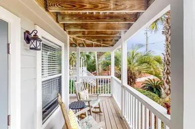 a porch with chairs and a table on it at Luxury home with private saltwater pool spa gazebo & deck - walk to beach in Santa Rosa Beach