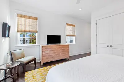 a white bedroom with a bed and a tv at Seagrove Serenity 4BR Coastal Retreat with Pool & Bikes in Santa Rosa Beach