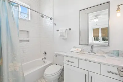 a white bathroom with a sink toilet and a mirror at Seagrove Serenity 4BR Coastal Retreat with Pool & Bikes in Santa Rosa Beach
