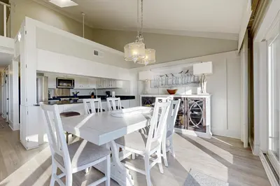 a dining room with a white table and chairs at Fourth floor oceanfront condo with pool access ocean views and washer&dryer in Santa Rosa Beach