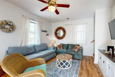 a living room with a blue couch and a ceiling fan at Dog-friendly bungalow with on-site pool hot tub free WiFi and washer&dryer in Santa Rosa Beach