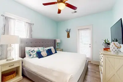a bedroom with a bed with a ceiling fan at Dog-friendly bungalow with on-site pool hot tub free WiFi and washer&dryer in Santa Rosa Beach