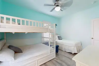 two bunk beds in a room with a ceiling fan at Dog-friendly bungalow with on-site pool hot tub free WiFi and washer&dryer in Santa Rosa Beach