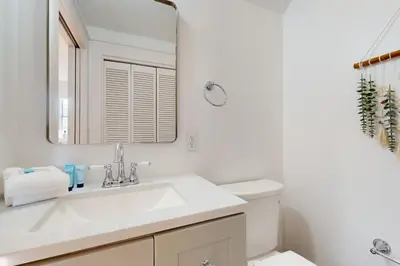 a white bathroom with a sink and a mirror at Dog-friendly bungalow with on-site pool hot tub free WiFi and washer&dryer in Santa Rosa Beach