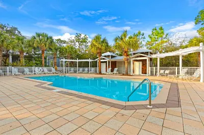 a swimming pool in a yard with a house at Coastal haven near the beach off scenic 30A with two pools & porch- dog-friendly in Santa Rosa Beach