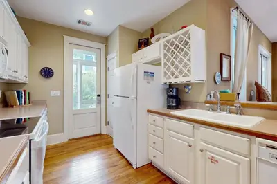 a kitchen with white cabinets and a white refrigerator at Coastal haven near the beach off scenic 30A with two pools & porch- dog-friendly in Santa Rosa Beach