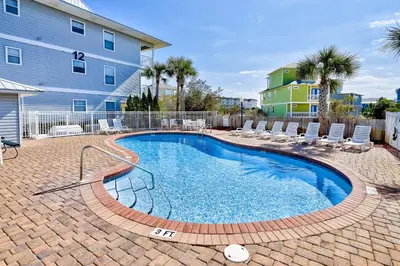 a swimming pool with chairs and a building at Seagrove Beach condo with AC pool & tennis - steps from the Gulf of Mexico in Santa Rosa Beach