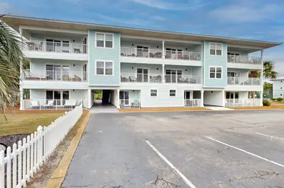 a large apartment building with a parking lot at Seagrove Beach condo with AC pool & tennis - steps from the Gulf of Mexico in Santa Rosa Beach