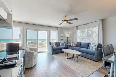a living room with a couch and a table at Delightful Beach Getaway with Water Views Beach Access Deck & Fast WiFi in Santa Rosa Beach