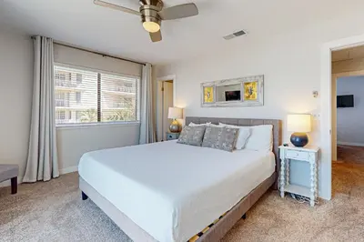 a bedroom with a white bed and a window at Delightful Beach Getaway with Water Views Beach Access Deck & Fast WiFi in Santa Rosa Beach
