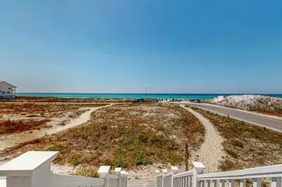 a road leading to a beach with the ocean at Delightful Beach Getaway with Water Views Beach Access Deck & Fast WiFi in Santa Rosa Beach