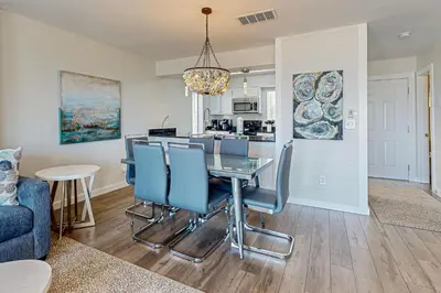 a dining room and kitchen with a table and chairs at Delightful Beach Getaway with Water Views Beach Access Deck & Fast WiFi in Santa Rosa Beach