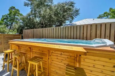 a pool deck with chairs and a hot tub at Spacious open concept one story home with pool bikes grill and pet friendly in Santa Rosa Beach