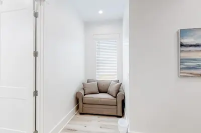 a chair in a room with a window at Spacious open concept one story home with pool bikes grill and pet friendly in Santa Rosa Beach