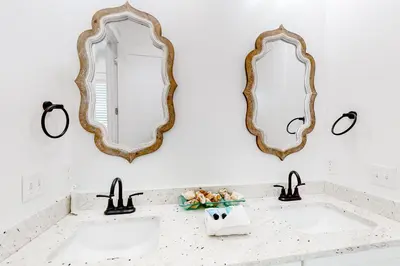 a bathroom with two sinks and two mirrors at Spacious open concept one story home with pool bikes grill and pet friendly in Santa Rosa Beach