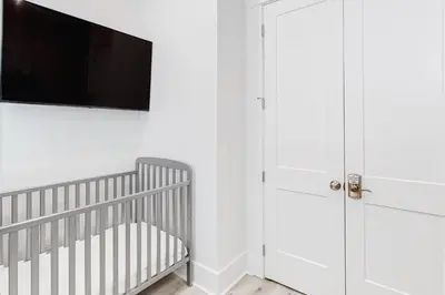 a nursery with a crib and a flat screen tv at Spacious open concept one story home with pool bikes grill and pet friendly in Santa Rosa Beach