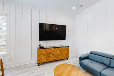 a living room with a blue couch and a tv at Spacious open concept one story home with pool bikes grill and pet friendly in Santa Rosa Beach