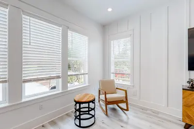 a living room with white walls and windows at Spacious open concept one story home with pool bikes grill and pet friendly in Santa Rosa Beach