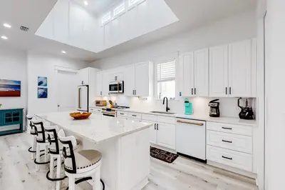 a kitchen with white cabinets and a large island at Spacious open concept one story home with pool bikes grill and pet friendly in Santa Rosa Beach