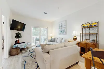 a living room with a couch and a tv at Third-floor condo with pool washer&dryer fast WiFi & central AC - near beach in Santa Rosa Beach