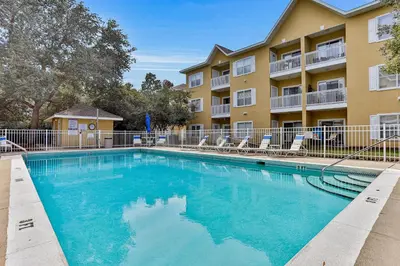 a swimming pool in front of a apartment building at Third-floor condo with pool washer&dryer fast WiFi & central AC - near beach in Santa Rosa Beach