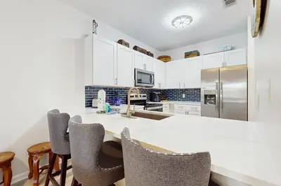 a kitchen with white cabinets and a white counter top at Third-floor condo with pool washer&dryer fast WiFi & central AC - near beach in Santa Rosa Beach