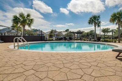 a swimming pool in a yard with palm trees at Dog-friendly home with pool patio & washer&dryer in Santa Rosa Beach