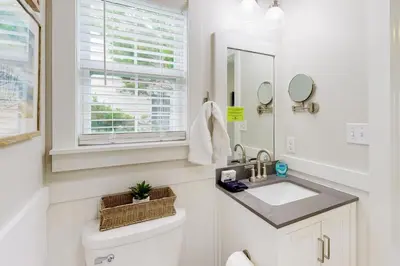 a white bathroom with a sink and a window at Dog-friendly home with pool patio & washer&dryer in Santa Rosa Beach
