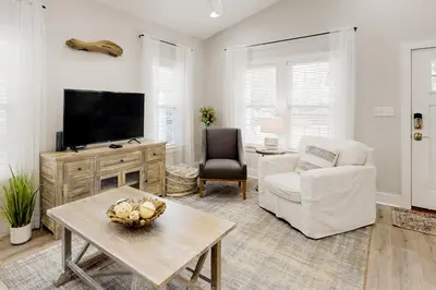 a living room with a tv and a couch and a table at Dog-friendly home with pool patio & washer&dryer in Santa Rosa Beach