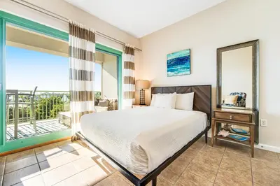 a bedroom with a bed and a balcony at Comfortable studio with shared outdoor pool hot tub BBQ area and pool views in Seacrest