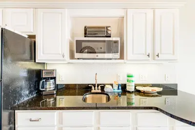 a kitchen with a sink and a microwave at Comfortable studio with shared outdoor pool hot tub BBQ area and pool views in Seacrest