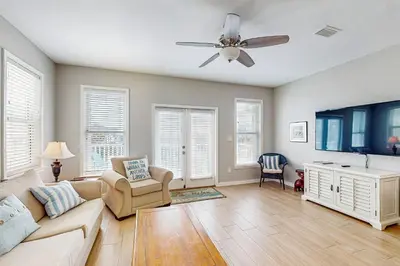 a living room with a couch and a ceiling fan at Spacious Seabreeze Trail home with gulf views & shared pool - short walk to beach in Seacrest